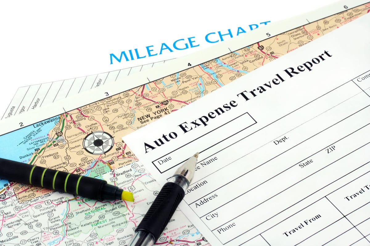Mileage chart and auto expense travel report form with map and pen for tracking business travel costs