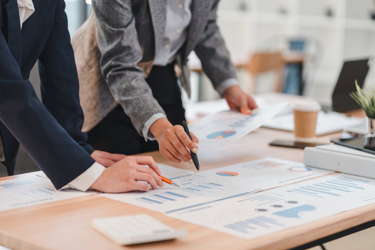 Business professionals analyzing financial charts in modern office